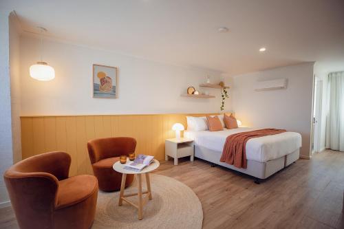 爱丽丝湾Sunnymead Hotel的一间卧室，里面有一张床、两把椅子和一张桌子