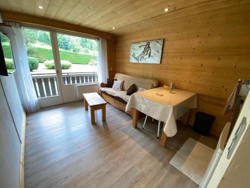 une pièce avec un canapé et une table dans une pièce dans l'établissement Studio cabine rénové avec balcon près des pistes et village à La Clusaz - FR-1-459-194, à La Clusaz