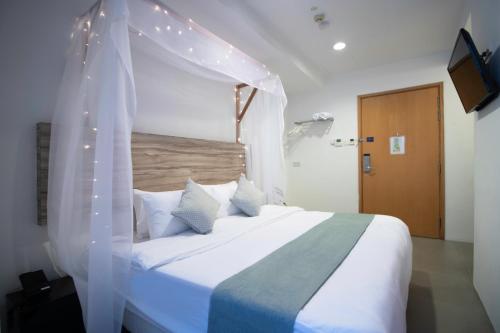 a bedroom with a white bed with a canopy at Victoria Hotel a NuVe Group Collection in Singapore