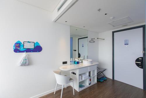 a bathroom with a sink and a mirror at SOJO Hotel Hau Giang in Vị Thanh