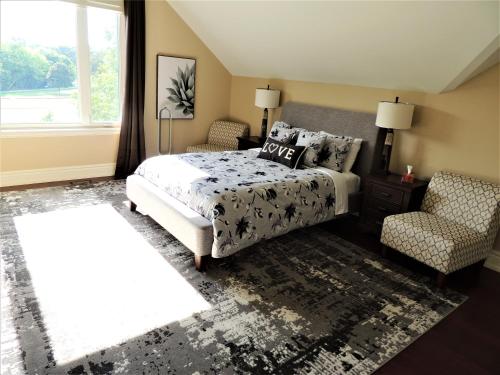 1 dormitorio con 1 cama, 1 silla y 1 ventana en iResidence in Toronto - LUX 3 Bedroom Vacation Home, en Toronto