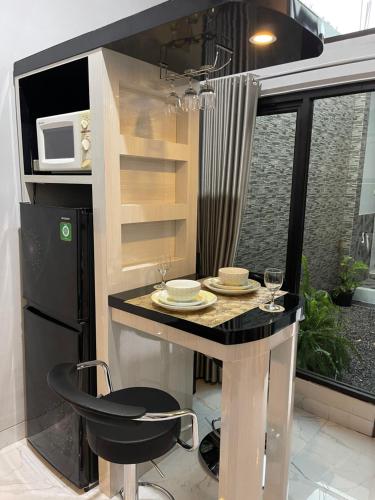 una pequeña cocina con mesa y microondas en AW Lor House - Yogyakarta, en Sleman