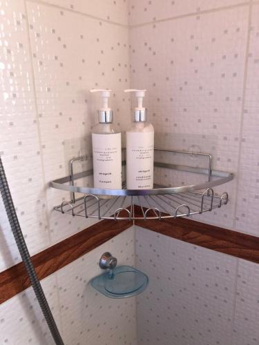 two bottles ofodorizers sit on a shelf in a bathroom at Hostal Qachi Chentura in San Pedro de Atacama