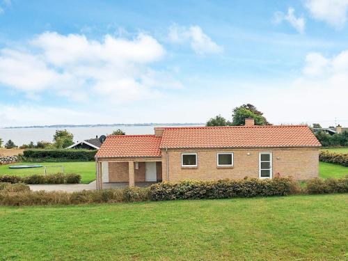 a house in a field with a grass yard at 8 person holiday home in Faaborg in Bøjden