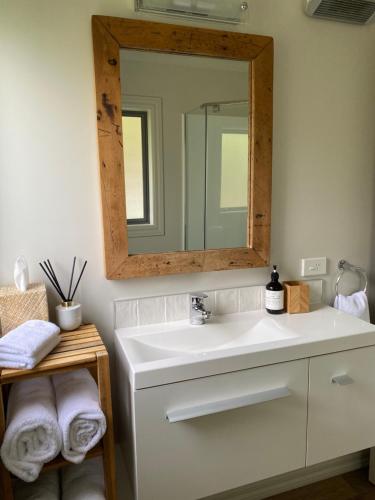 a bathroom with a white sink and a mirror at Foehn Cottage in Twizel