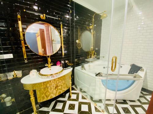 a bathroom with a tub and a sink and a mirror at Perles Villa - Venue Travel in Ha Long