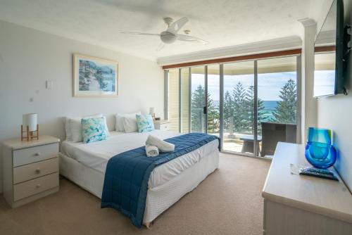 a bedroom with a bed and a large window at Cashelmara Beachfront Apartments in Gold Coast
