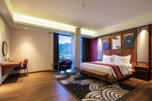 a hotel room with a bed and a large window at Parkside Gayo Petro Hotel Takengon in Takengon