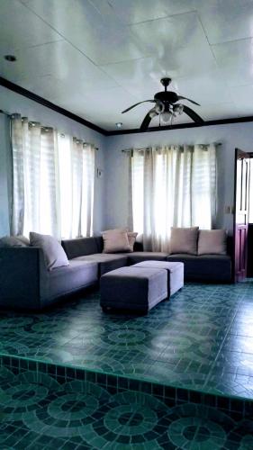 ein Wohnzimmer mit einem Sofa und einem Deckenventilator in der Unterkunft 5bedroom Home with Parking in Tarlac City