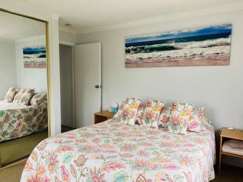 a bedroom with a bed and a mirror at Beachside spacious unit 9 in Tuncurry