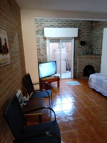 a living room with a table and a tv at PUNTO FIJO in Zárate