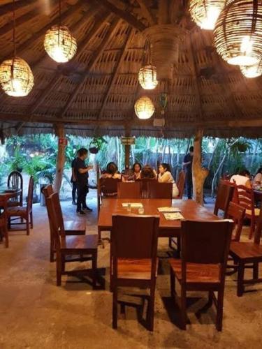 a restaurant with a wooden table and chairs and people at Villa Copa de Oro. Zona Diamante. Alberca Privada. Espacio Yocte in Acapulco