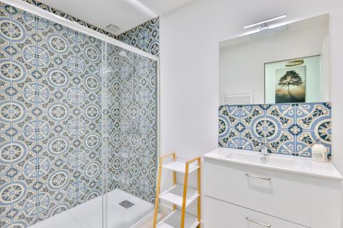 uma casa de banho com um chuveiro com azulejos azuis e brancos em Le Saint Martin #Centre ville #Charente #6pers em Cognac