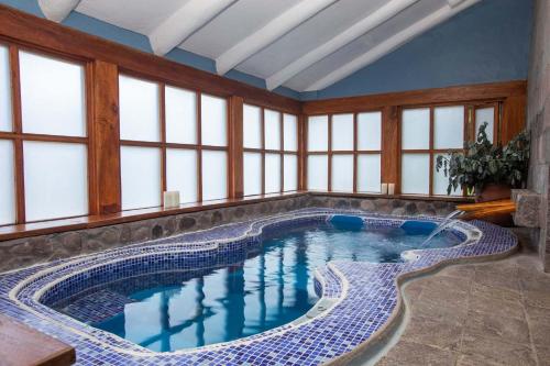 - une grande piscine dans une pièce dotée de fenêtres dans l'établissement Casa Andina Premium Valle Sagrado Hotel & Villas, à Urubamba