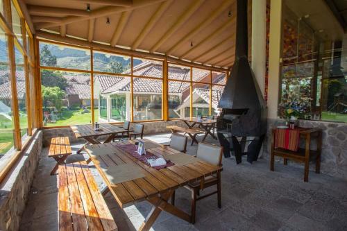 a large room with wooden tables and a stove at Casa Andina Premium Valle Sagrado Hotel & Villas in Urubamba