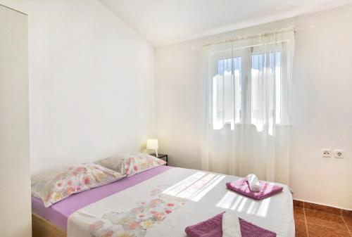 a bedroom with a bed with pink towels on it at Apartments Jera- barbecue in Sevid