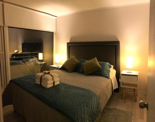 1 dormitorio con 1 cama grande y 2 mesitas de noche en Elegante y acogedor departamento con gran vista, cercano a todo, en Concepción