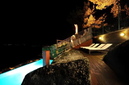 a bench sitting on a deck at night at Casas do Soito in Seia