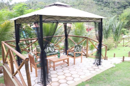 a gazebo with two chairs and a bench at Hotel Villa Babaçu in Jacobina