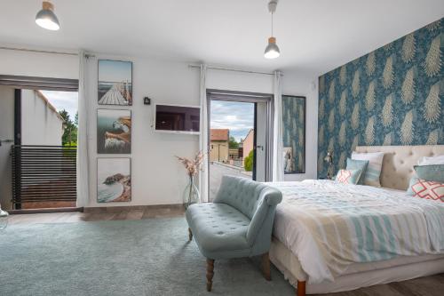 a bedroom with a bed and a blue chair at Spéciale Halloween - Idéal Familles & Groupes - 15min Parc Spirou - Nocturnes les 25, 30, 31 octobre et le 1er novembre - 10min Avignon - 5min Gare - Grand jardin clos - Parking gratuit - Au calme - Maison haut de gamme in Sorgues
