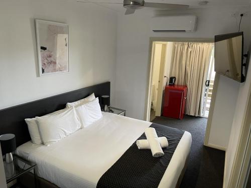 a hotel room with a bed with a towel on it at H Boutique Hotel in Pokolbin