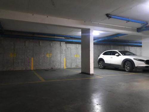 a white car parked in a parking garage at Elegante y acogedor departamento con gran vista, cercano a todo in Concepción