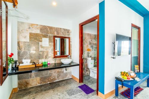 une salle de bain avec un lavabo et des toilettes dans l'établissement Relax Garden Boutique Villa Hoi An, à Hội An