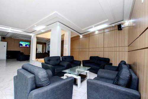 una sala de espera con sofás, mesa y TV en Hotel Galilée, en Cotonou