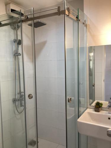 a shower with a glass door next to a sink at D' Residences in Cebu City