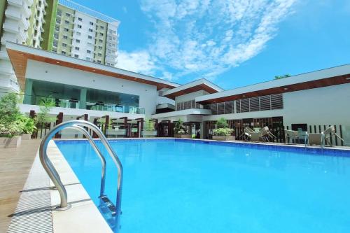 a swimming pool in front of a building at Cozy Mesaverte Condo Residences in Cagayan de Oro