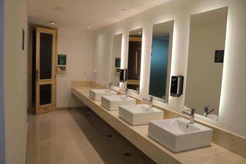 La salle de bains est pourvue de 4 lavabos et d'une rangée de miroirs. dans l'établissement GREEN PARK - Apartamento Torre J - Punta del Este - Resort & Spa, à Punta del Este