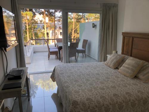 - une chambre avec un lit et un balcon avec une table dans l'établissement GREEN PARK - Apartamento Torre J - Punta del Este - Resort & Spa, à Punta del Este