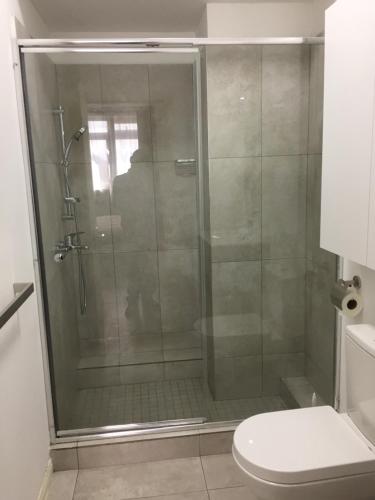 a shower with a glass door in a bathroom at BR COURT-PARKVIEW SODNAC in Quatre Bornes