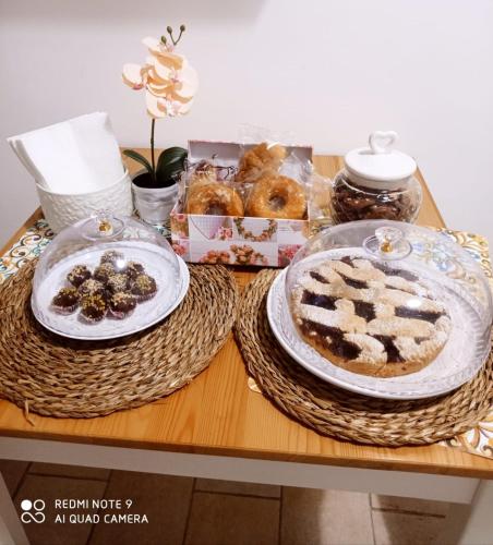 a table with two plates of cake and a box of donuts at La loggetta 63 in Palagianello