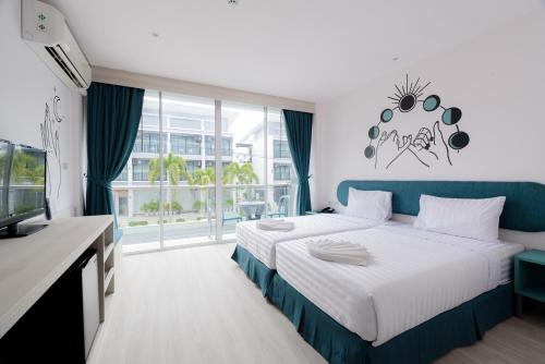 ein Hotelzimmer mit einem Bett und einem TV in der Unterkunft Moon Budget Hotel in Ao Nang Beach
