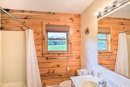 een badkamer met een houten wand met een spiegel bij Grand Windham Retreat with Fire Pit and Game Room in Windham