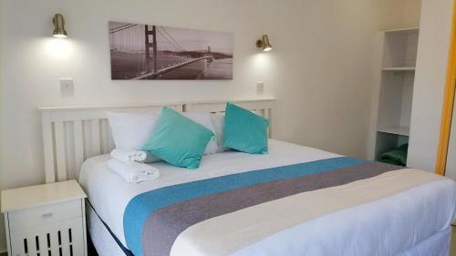 een slaapkamer met een bed met blauwe en witte kussens bij Royal relax guest house in Palatswe