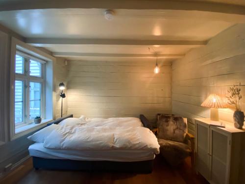 ein Schlafzimmer mit einem Bett, einem Stuhl und einer Lampe in der Unterkunft Charming Bergen house, rare historic house from 1779, Whole house in Bergen