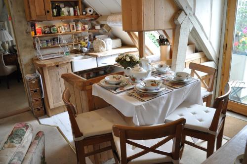 a table with a white table cloth on it in a kitchen at The Old Barn in North Stoke