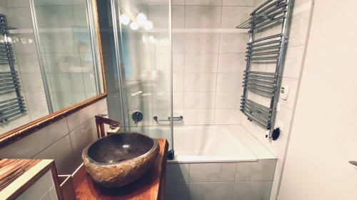 ein Badezimmer mit einem Waschbecken und einer Badewanne in der Unterkunft Lakeview Little House in Krattigen
