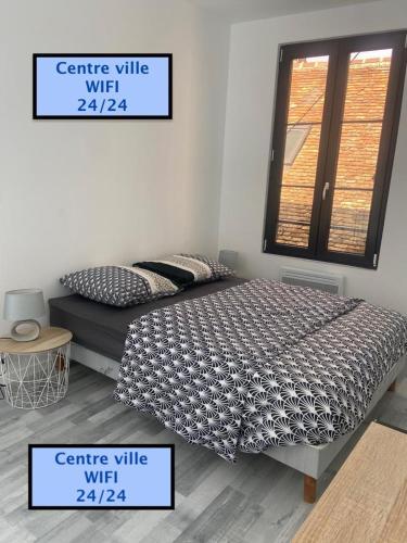 a bedroom with a bed and a window with two signs at La maison ZEN LOC 1 in Bray-sur-Seine