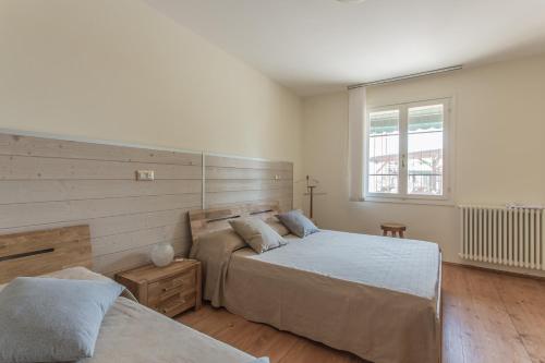 1 dormitorio con 2 camas y ventana en Apartment Ponte de Tola, en San Bellino