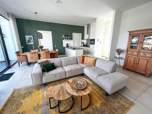 uma sala de estar com um sofá e uma mesa em Luxury holiday home in Zeewolde with garden and bubble bath em Zeewolde