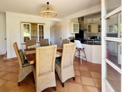 una cucina e una sala da pranzo con tavolo e sedie di SUPERBE VILLA-DOMAINE AVEC GOLF PISCINE ET TENNIS a Saint-Cyr-sur-Mer