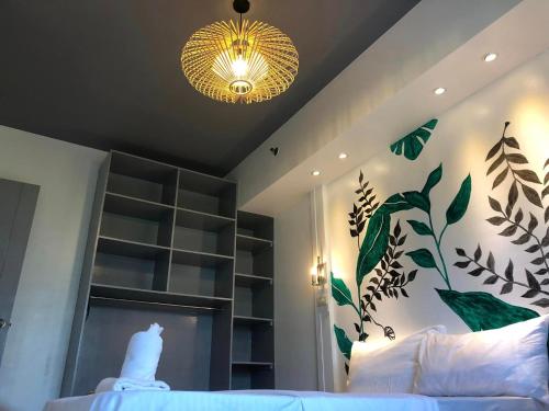 a bedroom with a bed and a chandelier at Premiere Haven MOA Staycation in Manila