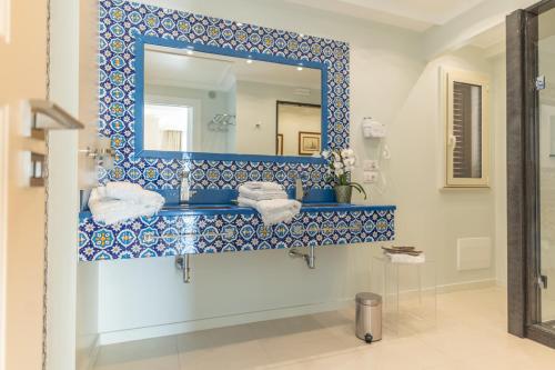 a blue and white bathroom with a sink and a mirror at Taormina Skyline in Taormina