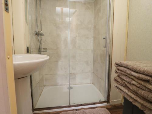 a shower with a glass door next to a sink at Hillcrest Croft in Preston