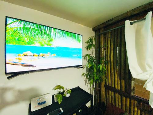 a flat screen tv hanging on a wall at Joyful Hut with Netflix and Perfect Sunrise View Maya, Daanbantayan 