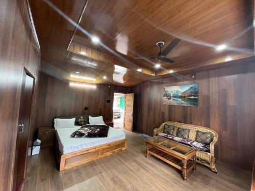 a bedroom with a bed and a couch in a boat at Ramneek Homestay in Joshīmath