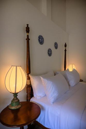 a bedroom with a bed and a table with a lamp at Moi Talpe by DBI in Talpe